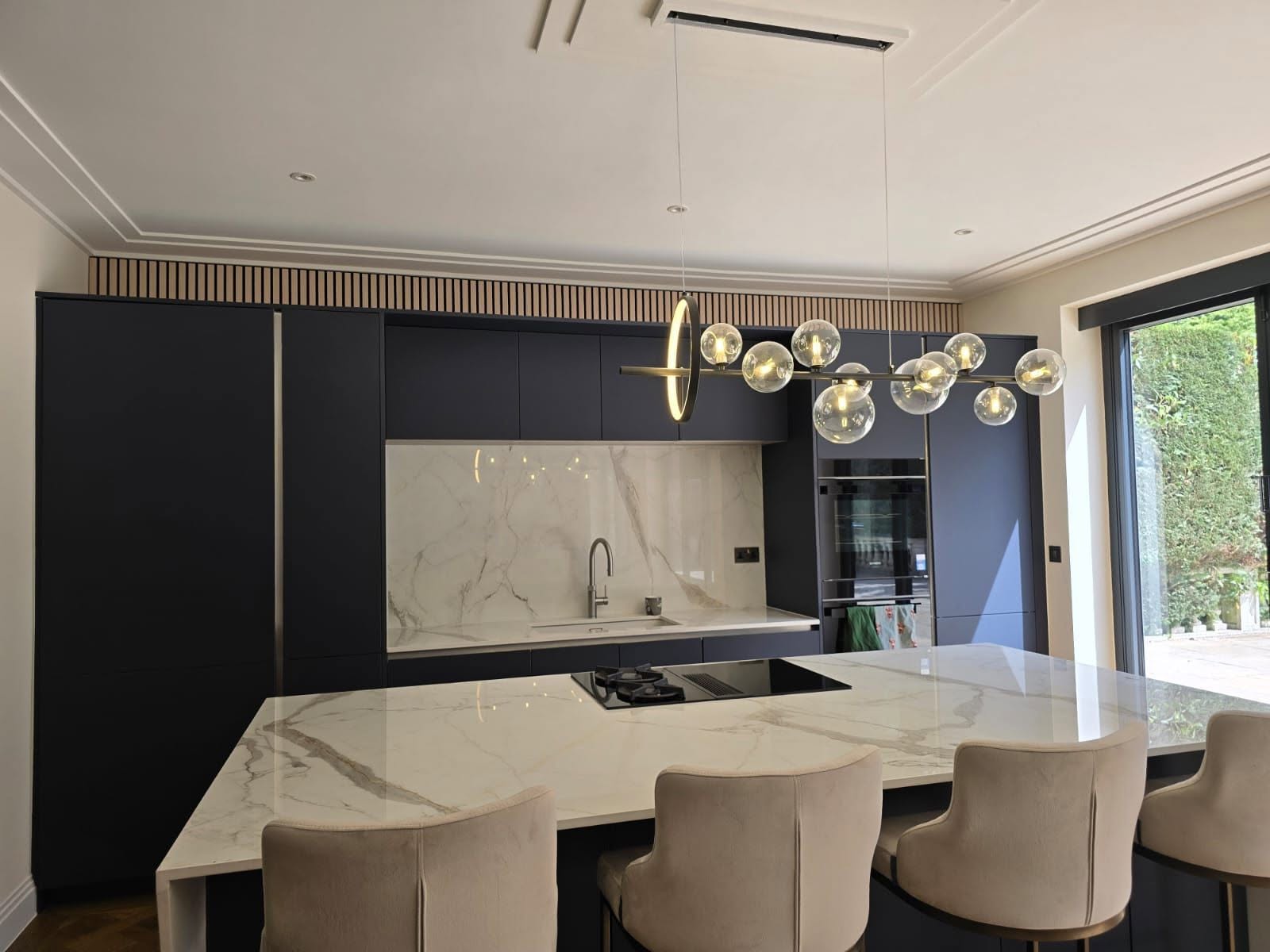 Marble kitchen island and induction hob detail in a completed kitchen extension