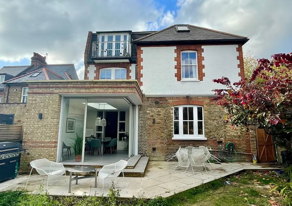 Rear elevation of a renovated brick house with a modern glazed extension