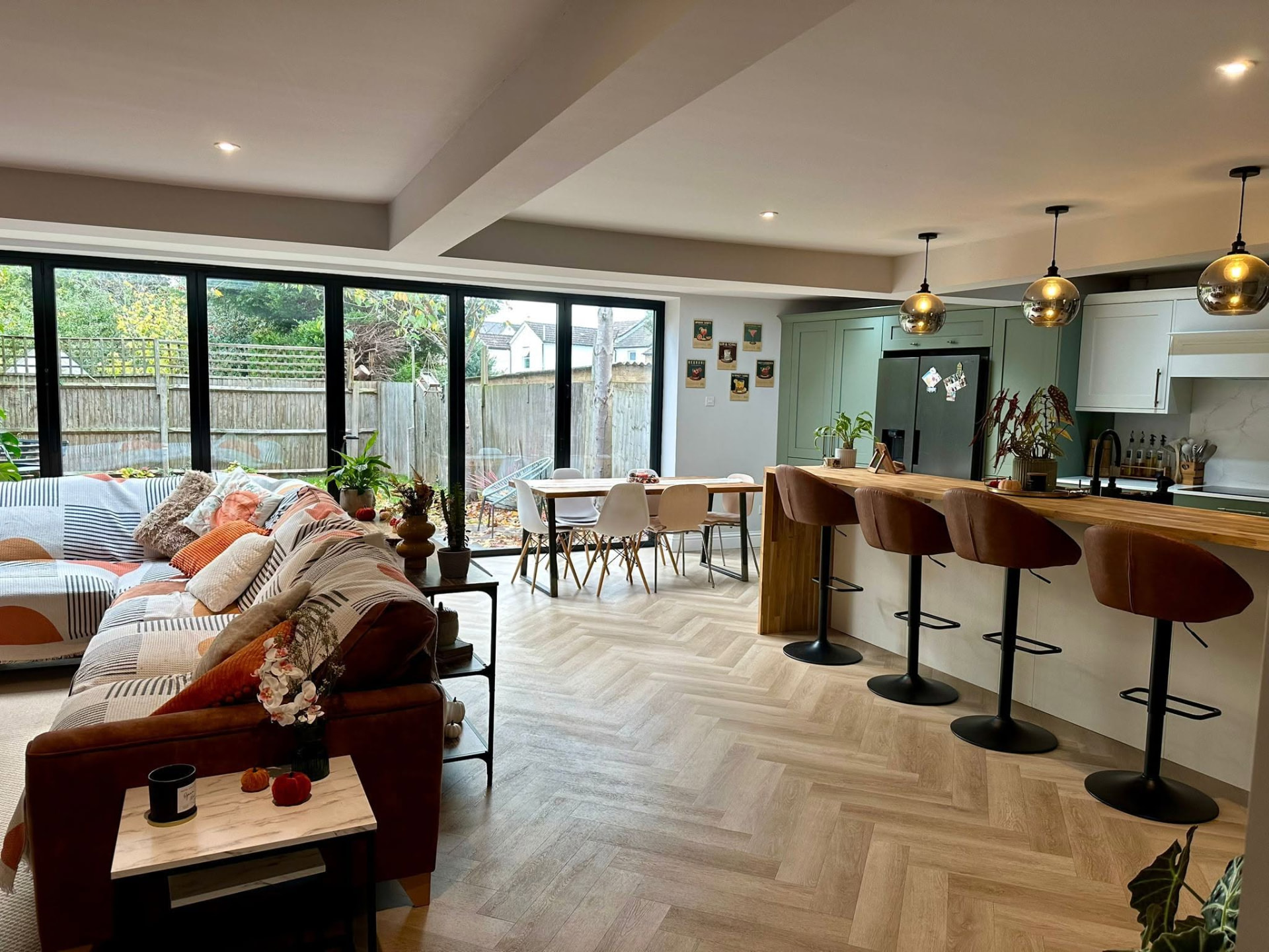 Open-plan kitchen extension with herringbone oak flooring and black-framed bi-fold doors