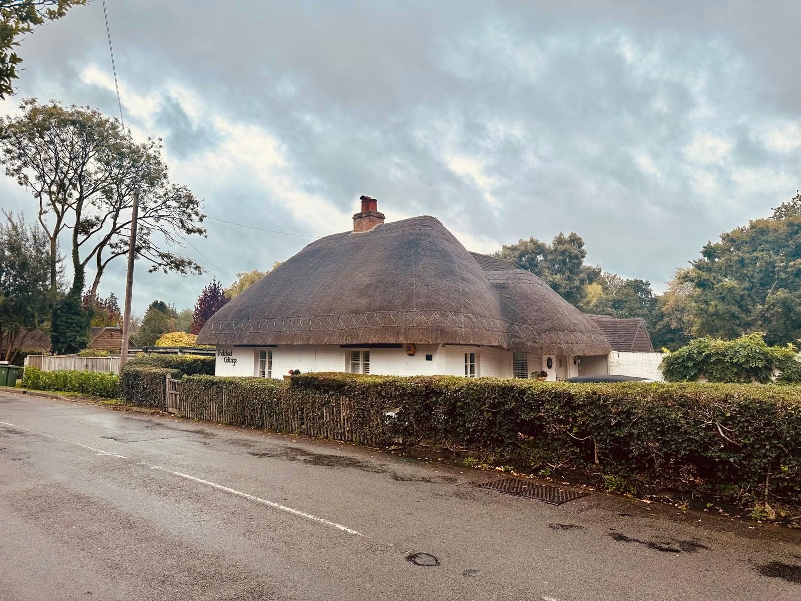 Exterior of a white thatched cottage refurbished by SMART Developments