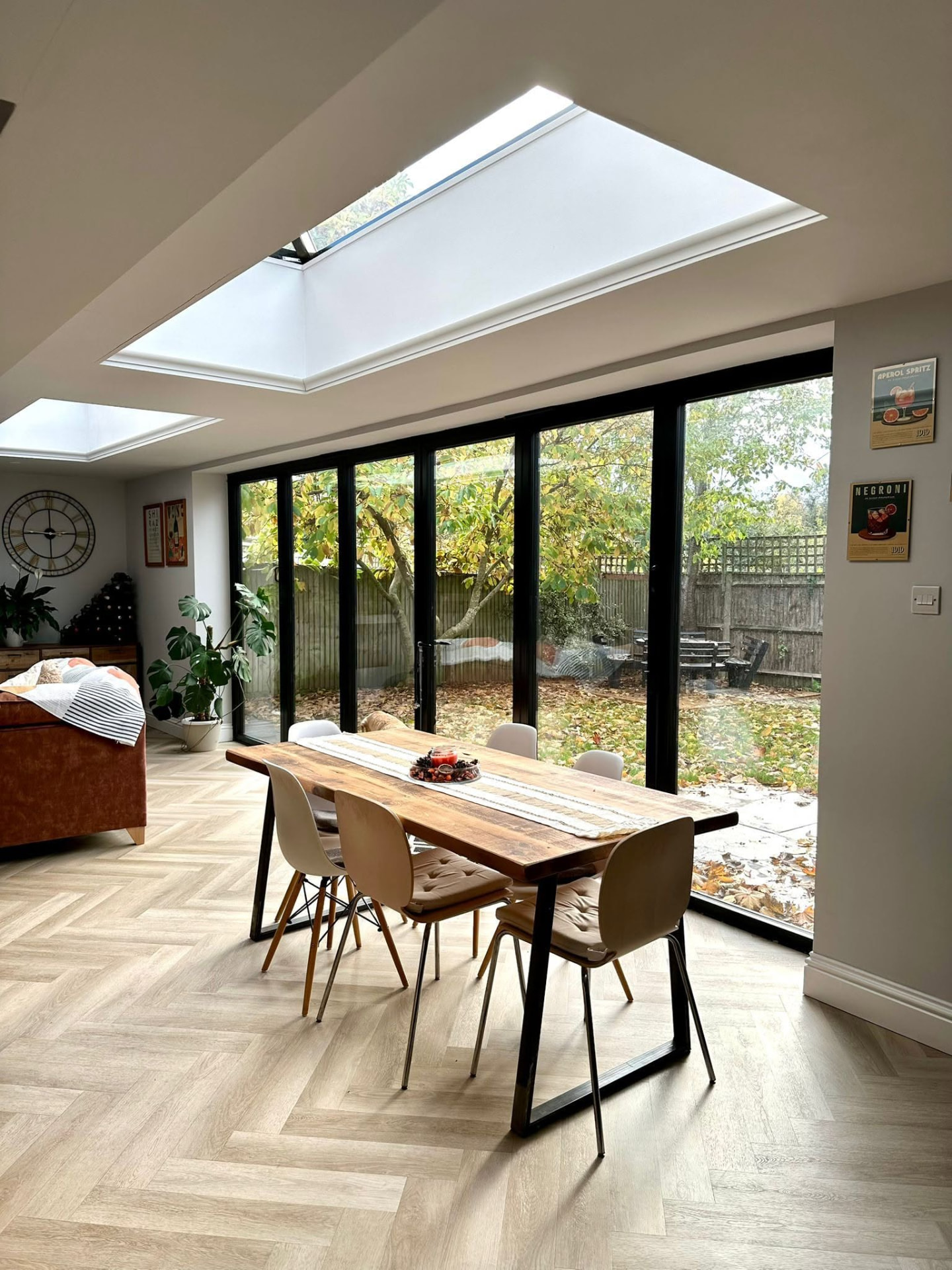 Extension dining space beside a full wall of black-framed folding glass doors